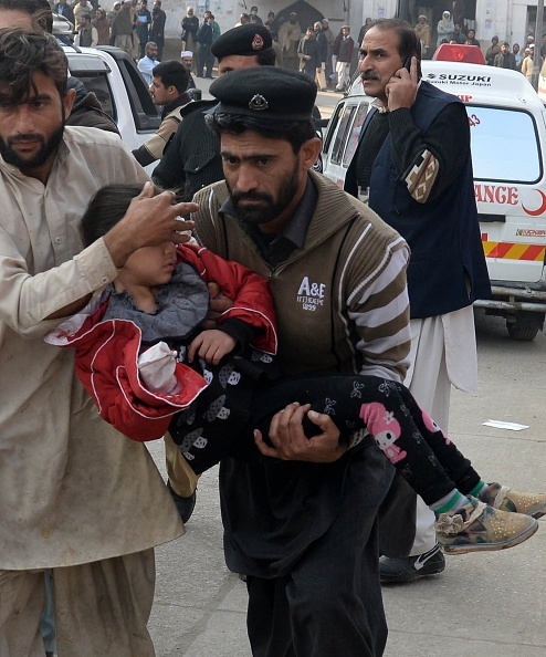 pakistan-taliban-peshawar-pakistani-men-carry-an-injured-school-girl-to-a-hospital-following-an-attack-by-taliban-gunmen-on-a-school-in-peshawar-on-december-16-2014